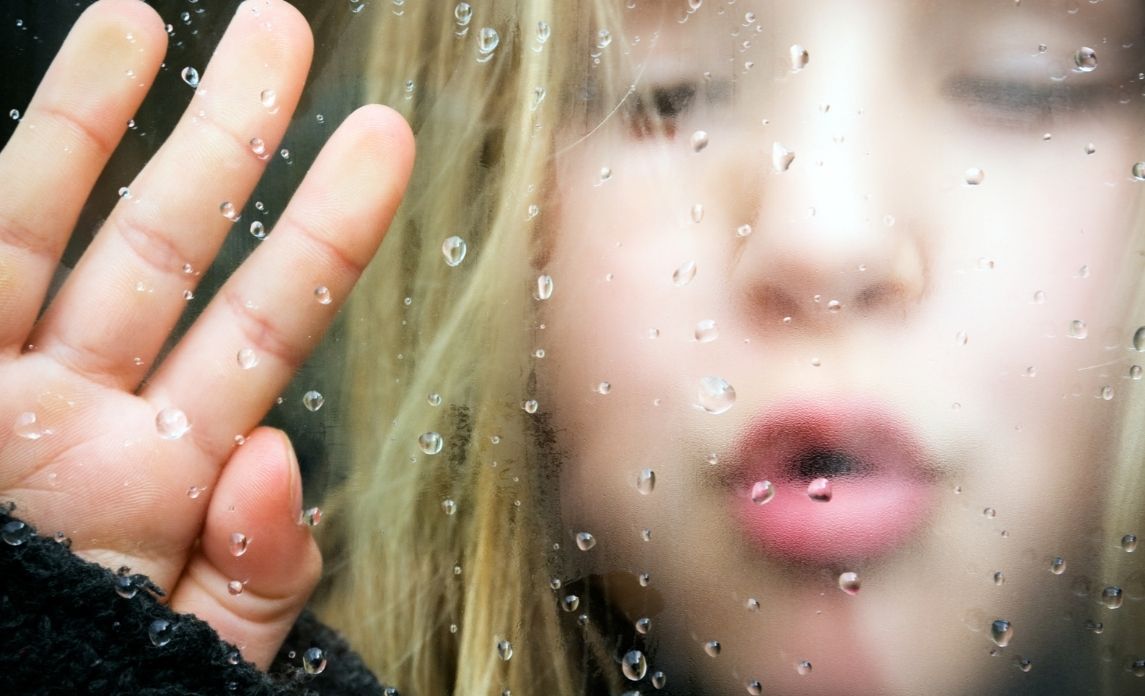 Child by the window with condensation