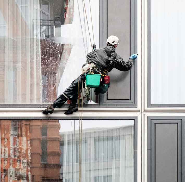 window cleaner has his helmet polished